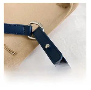 Detailed close-up of blue leather strap with silver D-ring buckle and canvas material