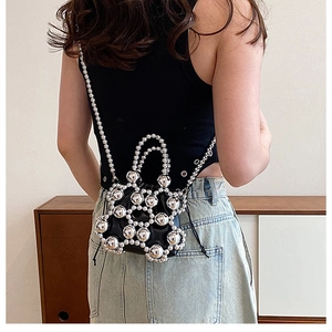 Rear view of a black leather mini bag with large silver spheres and chain strap
