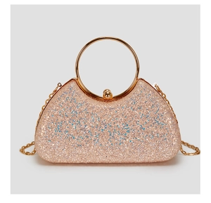Close-up of curved evening bag featuring glitter sequins and gold ring handle details