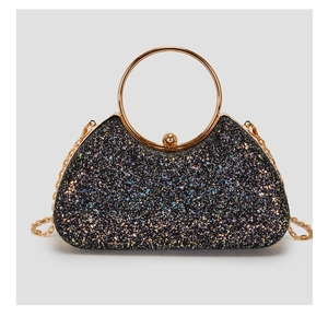 Close-up of black glitter evening clutch featuring gold ring handle and metal chain strap