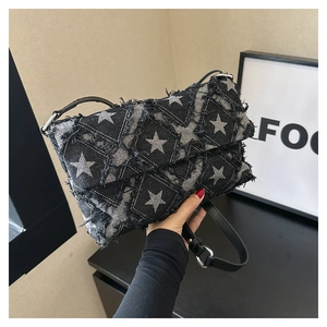 Detail of star-patterned denim bag featuring distressed frayed edges and metallic buckle