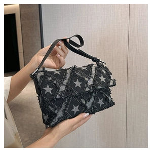 Detail of star pattern denim bag with quilted texture and distressed fringe edges