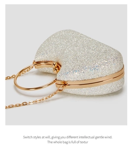 Macro detail of heart-shaped evening bag with glitter texture and gold metal frame