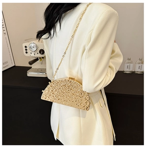 Detail showing a golden half-moon evening bag with hammered texture and chain strap