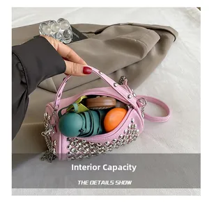 Pink cylinder rhinestone bag interior showing capacity for cosmetics and a mini umbrella