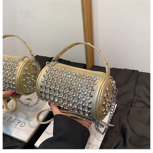 Detail of gold crystal barrel bag with metallic chain strap and sparkling rhinestones