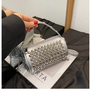 Macro view of silver cylindrical handbag with studded rhinestones and chain strap