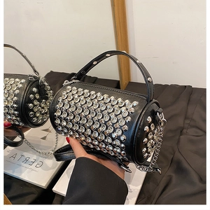 Detailed close-up of a black cylinder bag with sparkling silver studs and chain strap