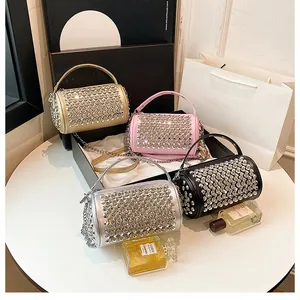 Detailed view of glittering rhinestone cylinder handbags in gold, silver, pink, and black