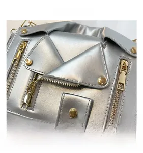 Close-up of silver biker jacket bag showing metallic texture and golden zippers