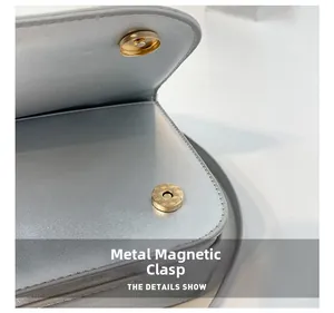 Close-up of golden magnetic snap closure on metallic silver textured leather handbag