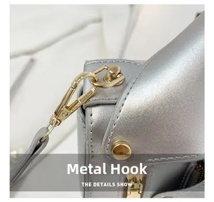 Macro shot of silver PU leather detail with polished gold metal lobster clasp hook