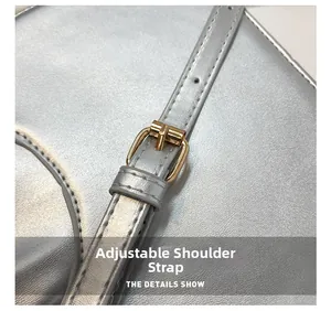 Detail of adjustable silver leather shoulder strap with gold metal buckle hardware