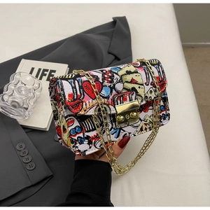 Detail of graffiti print small crossbody bag with gold chain and metal twist lock