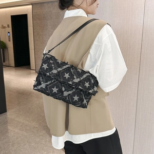 Star pattern grey denim crossbody bag with quilted stitching and distressed frayed edges
