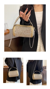 Detailed view of a gold cylindrical bucket bag featuring sparkling rhinestones and chain