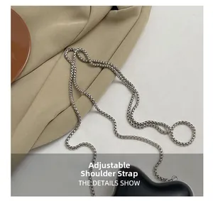 Vue détaillée de la bandoulière chaîne en métal argenté réglable du mini sac noir