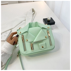 Close-up of mint green biker jacket crossbody bag featuring gold zippers and stud details