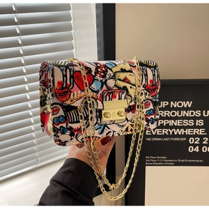 Close-up of white graffiti print PU crossbody bag with golden chain and metal lock