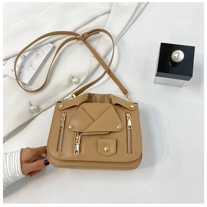 Detail of tan biker jacket style bag featuring golden zippers and textured PU leather