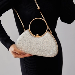 Sparkly silver evening bag with a gold circular handle and crossbody chain strap