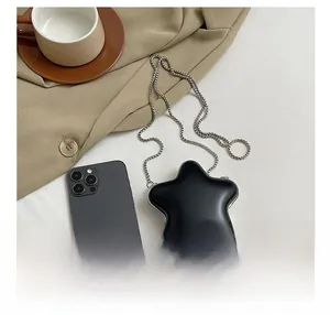 Détail du mini sac noir en forme d'étoile avec chaîne et finitions métalliques argentées