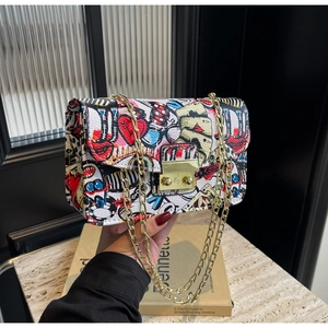 Detailed view of pop art graffiti print on PU leather crossbody bag with gold chain strap