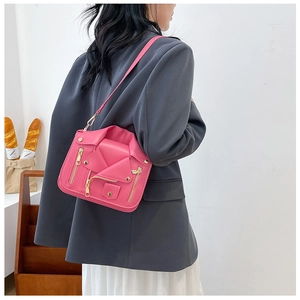 Pink moto jacket crossbody bag with metallic zipper details and gold chain strap