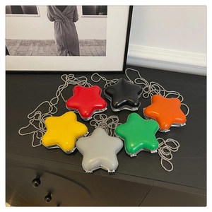 Vue à plat de sacs rigides colorés en forme d'étoile avec chaînes argentées sur bureau