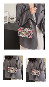 Close-up of the creative graffiti print PU leather crossbody bag with a gold chain strap