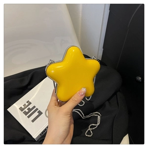 Détail d'un mini sac bandoulière jaune en forme d'étoile avec chaîne en métal argenté