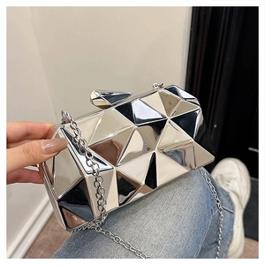 Detail of silver geometric box bag with metallic texture and sleek chain strap