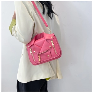 Pink moto jacket crossbody bag with gold zippers worn by model in white blazer