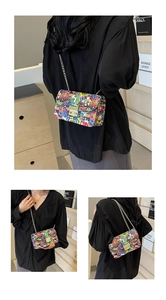 Detail view of the colorful graffiti print and golden metal chain strap on this PU bag