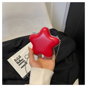 Vue détaillée d'un mini sac rouge en forme d'étoile avec fini brillant et chaîne argentée