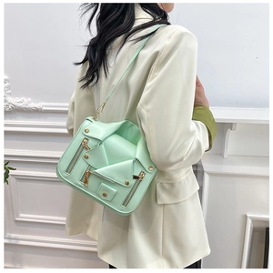 Close-up of mint green biker jacket style crossbody bag with gold stud hardware