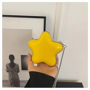 Détail du mini sac jaune en forme d'étoile avec bordures métalliques et chaîne