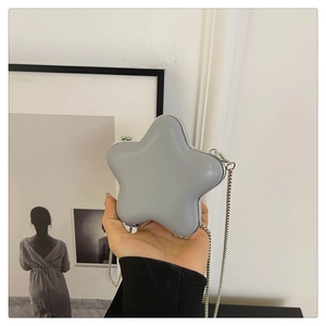 Gros plan d'un mini sac bandoulière gris en forme d'étoile avec chaîne en argent