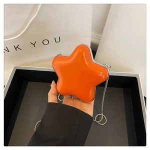 Détail du mini sac étoile orange avec bordure en métal argenté et bandoulière chaîne