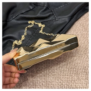 Close-up of golden geometric crossbody bag with a metallic finish and chain strap