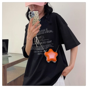 Petit sac orange en forme d'étoile avec chaîne en métal porté en selfie miroir