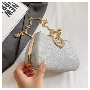 Detail of silver glitter evening clutch with rhinestone ring clasp and gold chain strap
