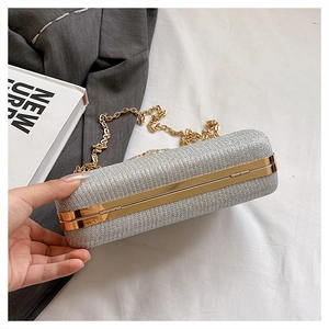 Detail of silver glitter evening clutch with gold metal frame and delicate chain strap