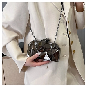 Detail of geometric faceted mirror clutch bag with chain strap and metallic lock