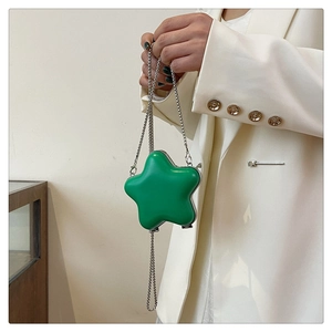Vue rapprochée du sac en forme d'étoile verte avec chaîne argentée et fini brillant