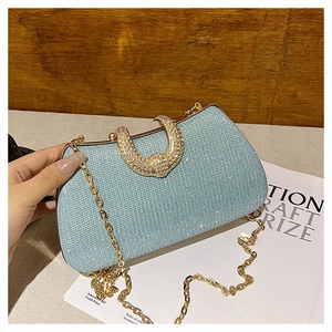 Detail showing high-end sky blue evening bag with shiny rhinestones and gold crescent buckle