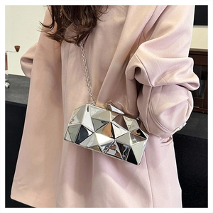 Silver geometric box bag with mirror finish and metal chain strap shown on pink outfit