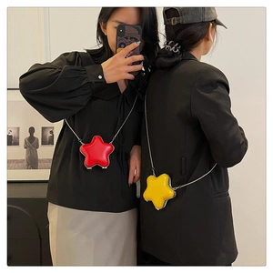 Détail des mini sacs étoiles rouge et jaune en cuir verni avec bandoulière chaîne