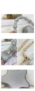 Macro shot of silver sequin star bag showing pearl handle and gold chain details