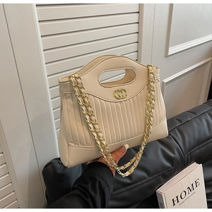 Detail of beige pleated tote bag with golden double-ring lock and woven chain strap
